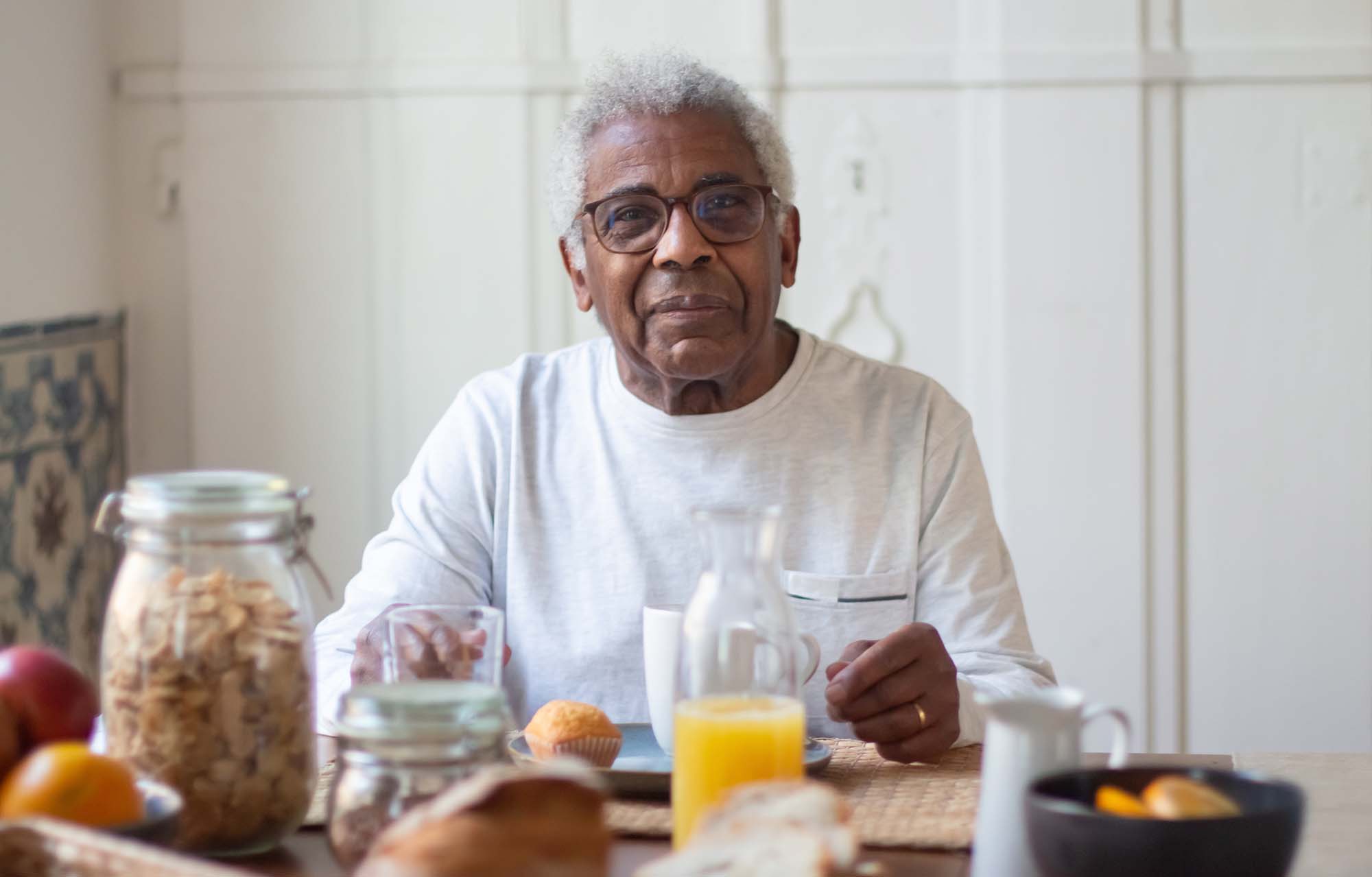 Portrait of aged man resting before breakfast in kitchen